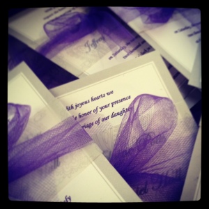 Gray invitations were printed in purple and wrapped with purple tulle bow.